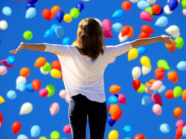 Ce texte représente une femme qui ouvre les bras devant plein de ballons